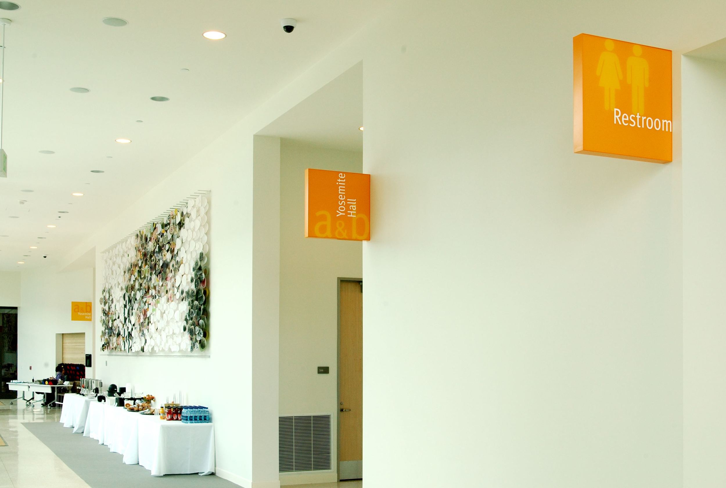 ...second-surface painted background to match frame returns, slight reveal between acrylic panel border and frame, and surface applied vinyl die cut room name graphics.