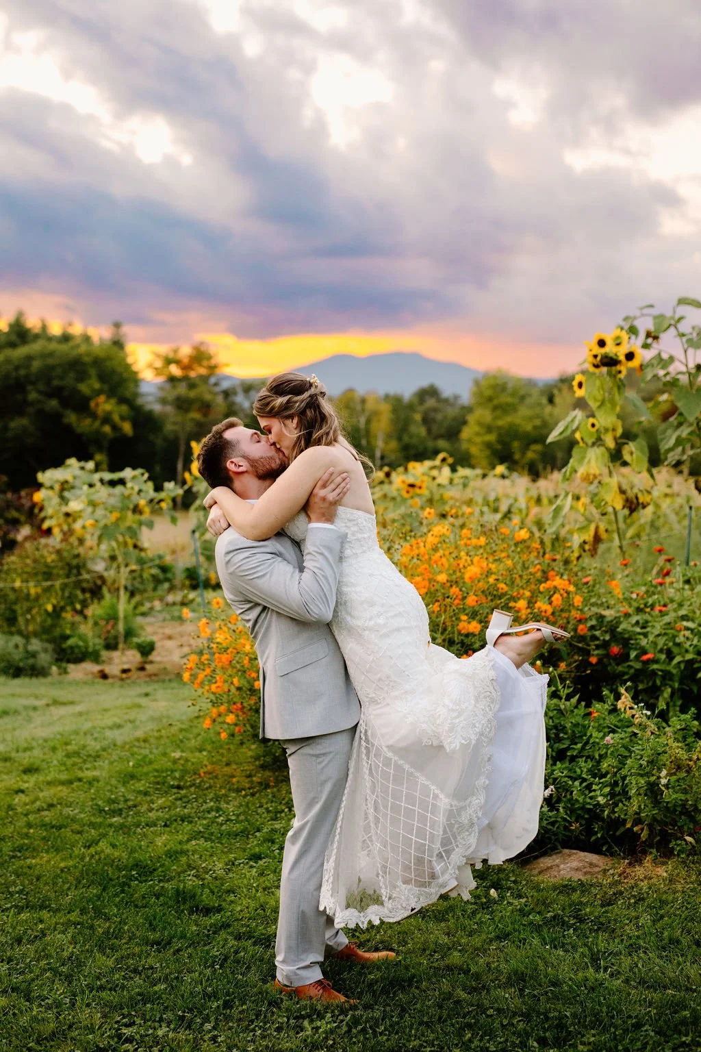 couple kissing in a field of sunflowers at sunset in the white mountains