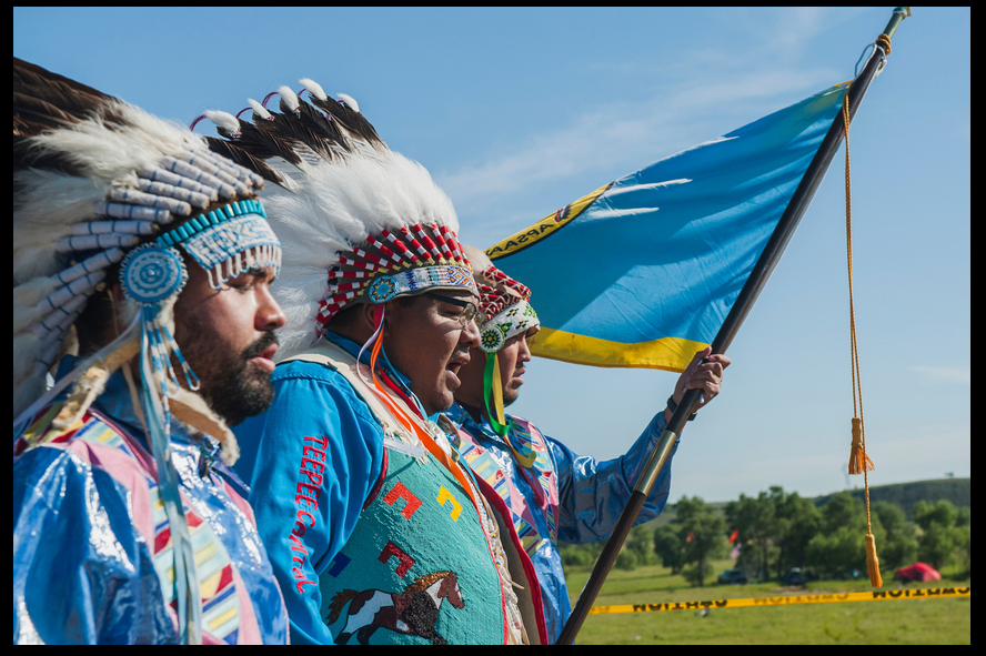 Darrin Old Coyote, chairman of the Crow Nation, enters a prayer camp with Nigel Stewart, left, and Taylor Real Bird, right, both Crow tribal members and U.S. military veterans, to offer support to the Standing Rock Sioux’ fight against the Dakota Access pipeline. The Crow and Sioux nations were once enemies, and Old Coyote's appearance was considered a historic event by many in attendance. (Photo courtesy High Country News)