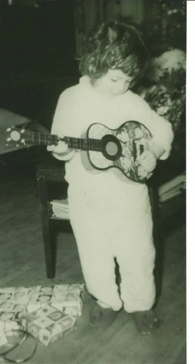 me playing a monkeys guitar very young.jpg