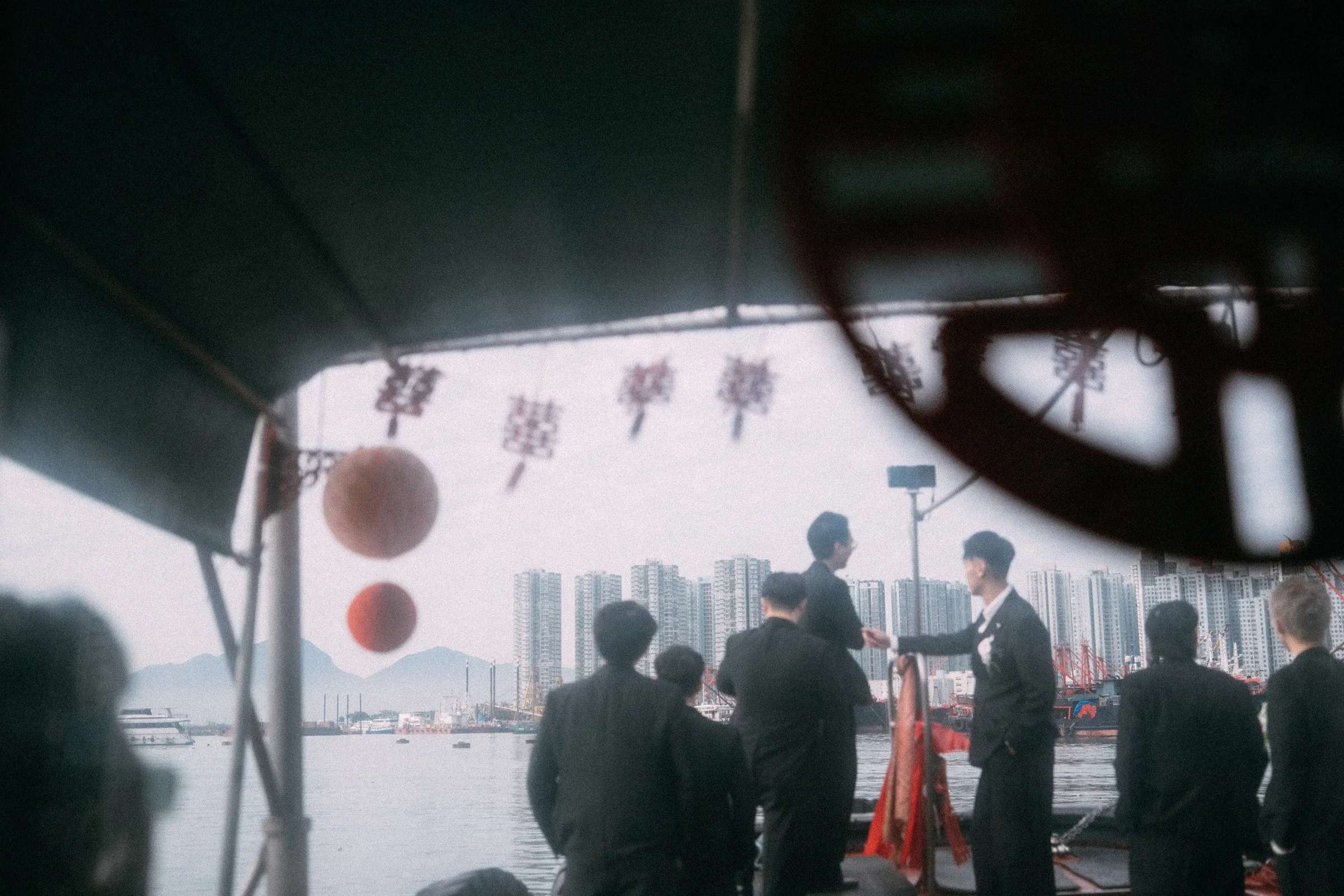透過船艙玻璃看見乘艇去接新娘的Alex與兄弟