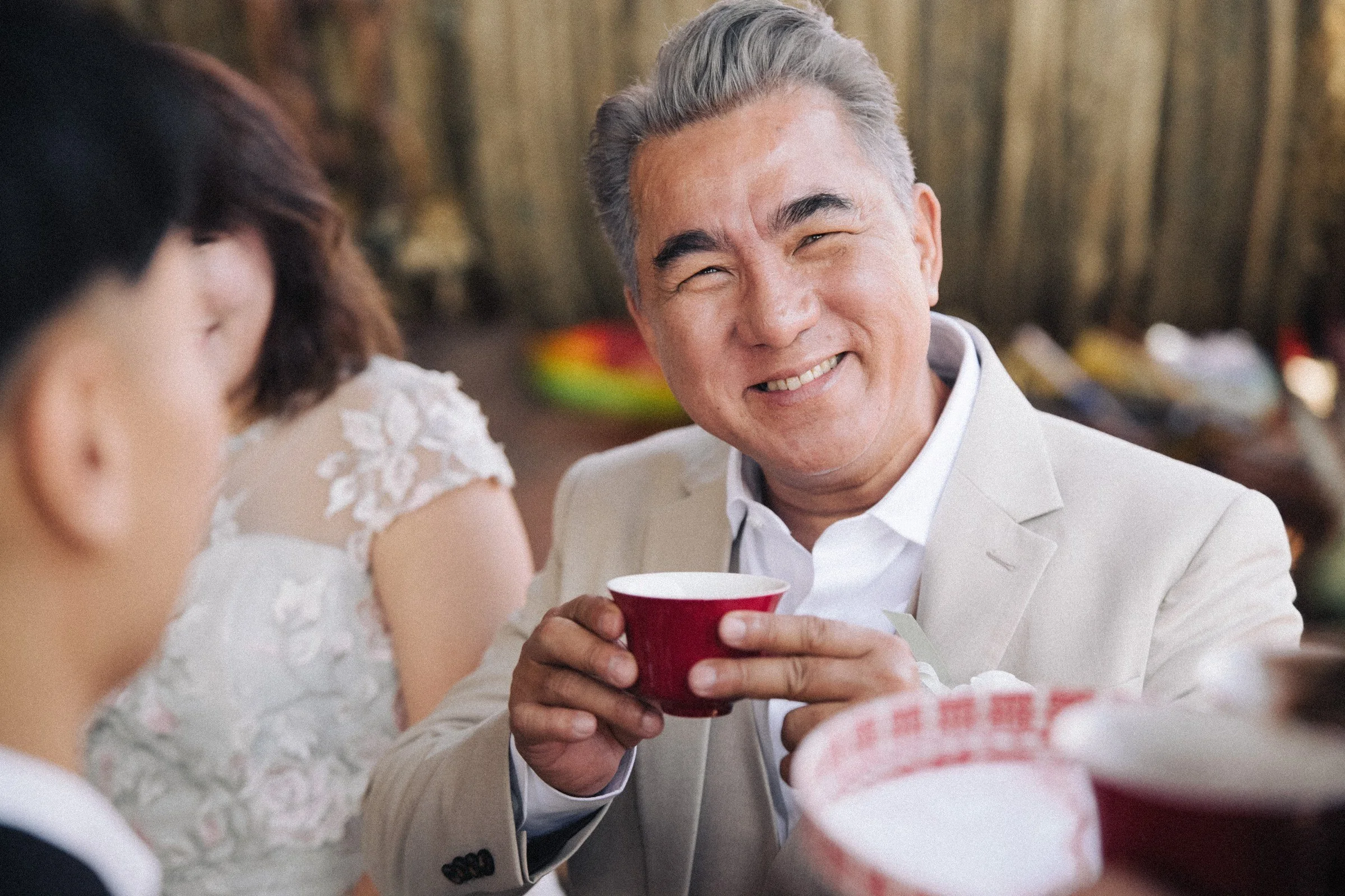 船上敬茶，爸爸添福手持紅色茶杯笑着看向新人