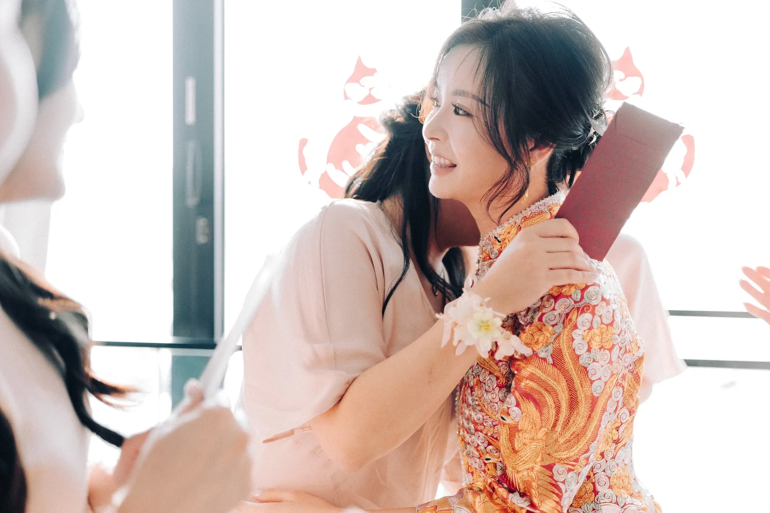 新娘 Charlie 與姊妹擁抱,手上拿着利是