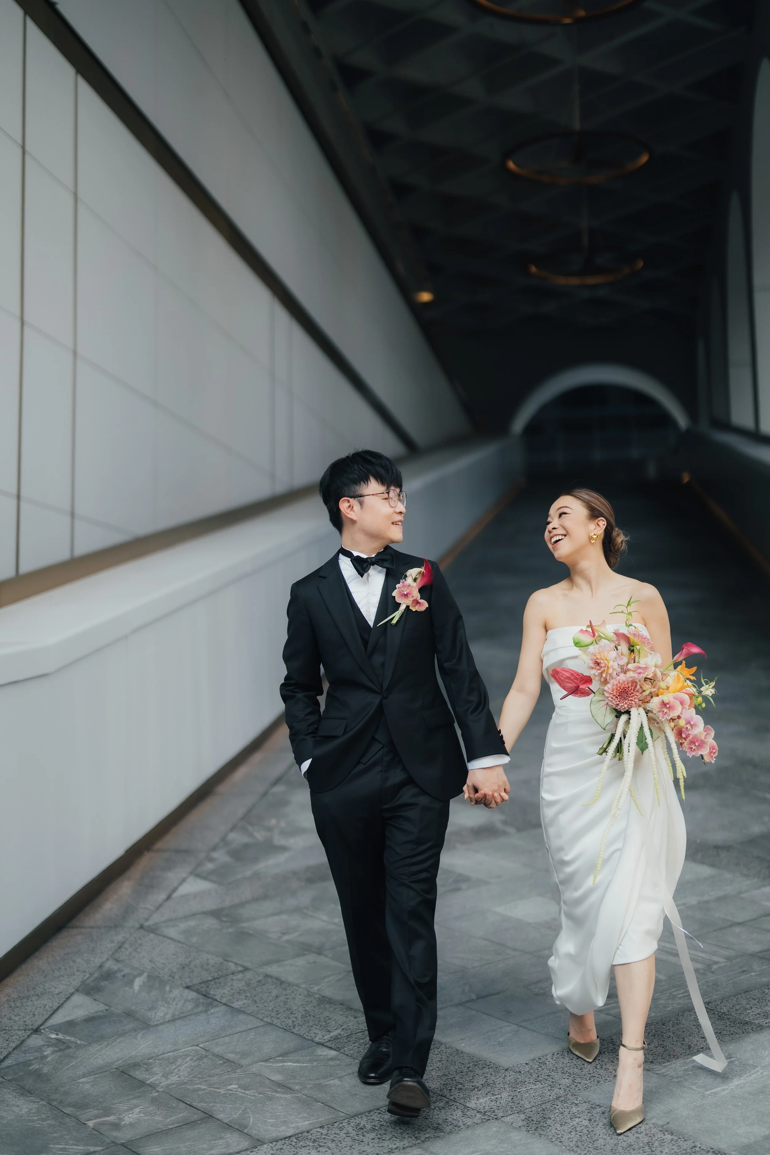 Phoebe and Jacky walking through The Murray Hong Kong with their wedding party.