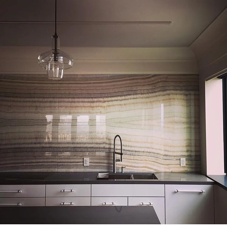 After: double book matched onyx, open to the rest of the apartment. No upper cabinets for these minimalists! I salute them!
