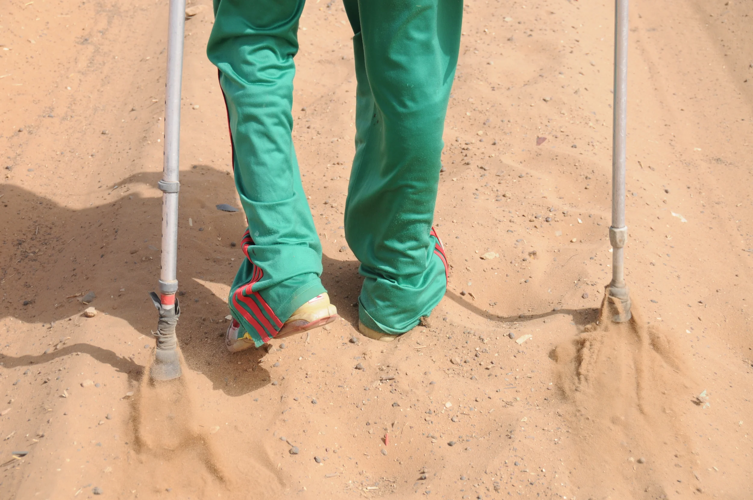 Faye uses his briquee—metal crutches—to trudge through the sandy Dakar walkways.    