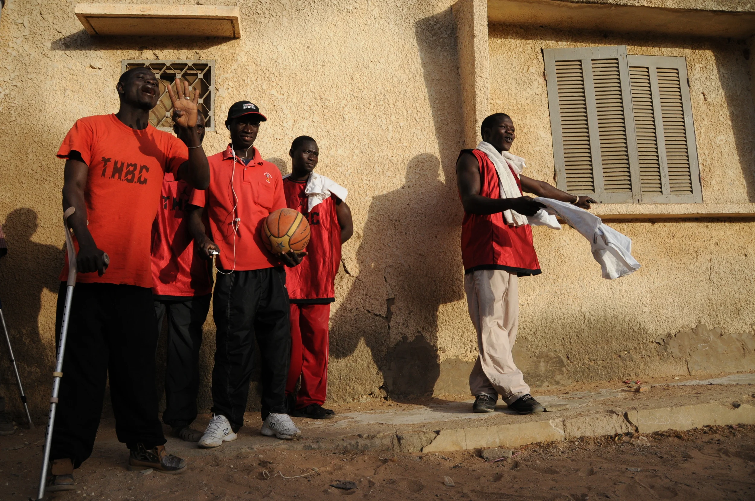 A player on the handicapped basketball team from Dakar yells out the score to passerby after their first win. 