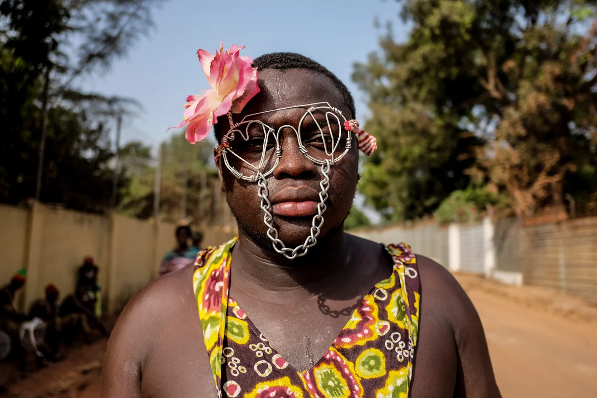 Bissau, Guinea-Bissau (February 6, 2016) - A spectator in wire glasses waits for Carnaval festivities to begin in Bissau, Guinea Bissau.