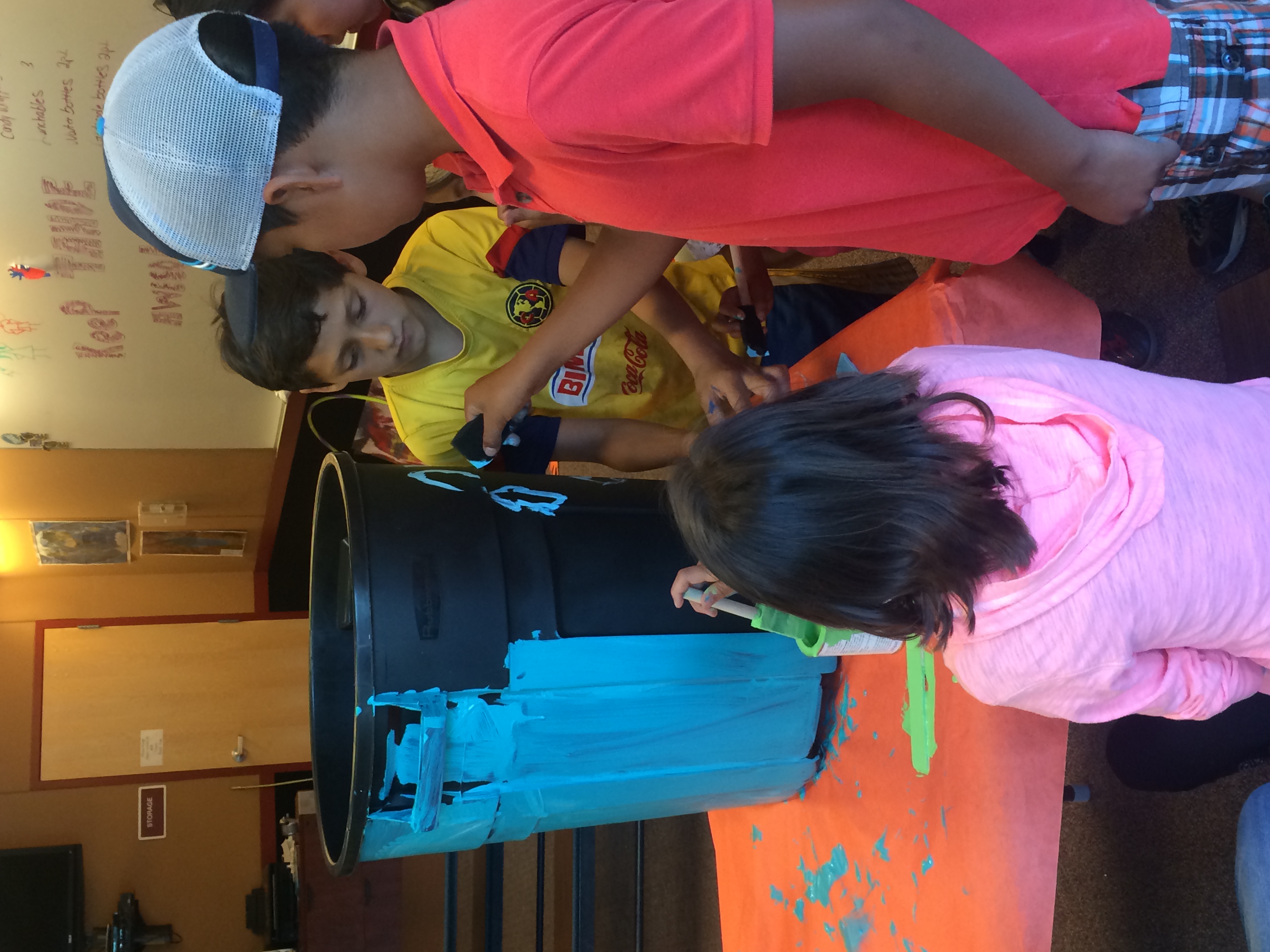 These club members are focused and hard at work decorating their recycling bin with detail