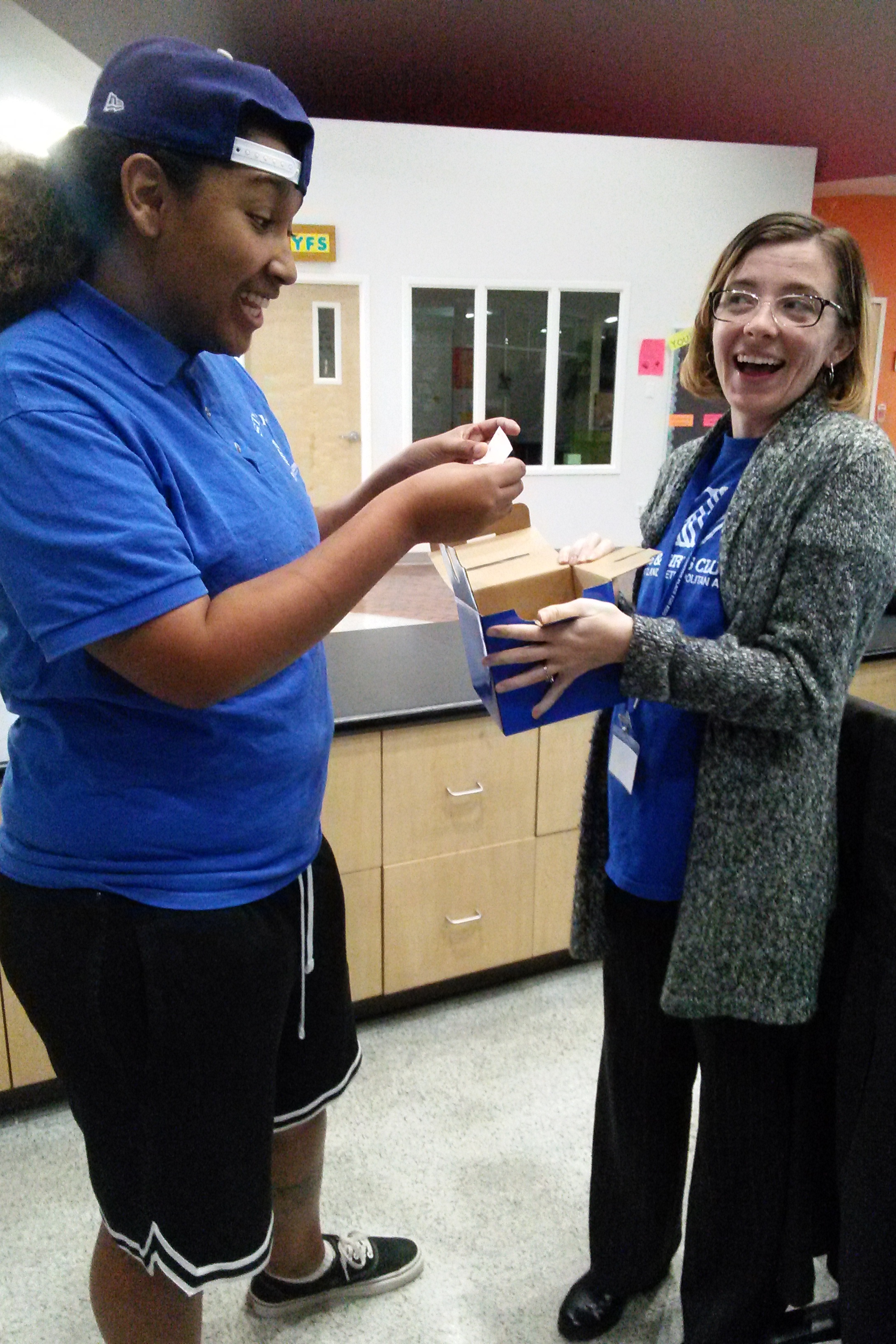 Rachel and a Youth Development Associate select a winner from those who completed her resources survey.