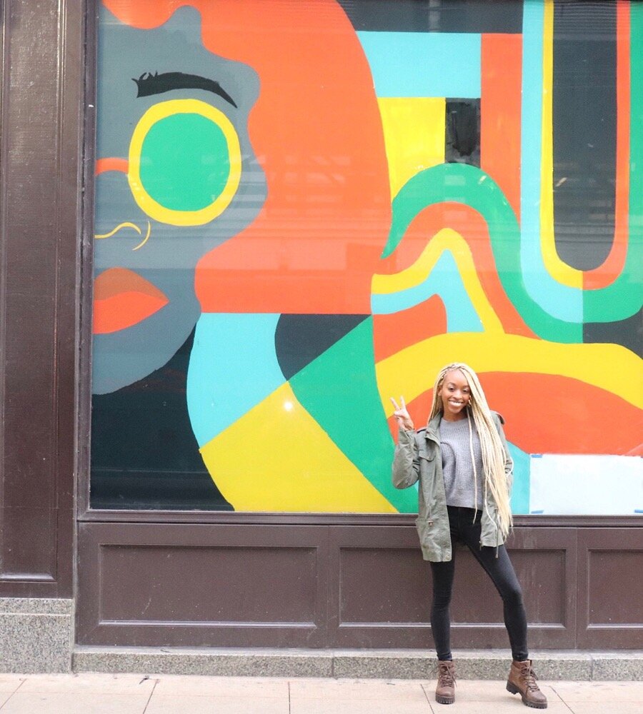  Brittany in front of a mural she created. The mural was created in partnership with the Chicago Loop Alliance. The  goal is to beautify the area and attract&nbsp;potential&nbsp;clients to vacant  storefronts in the loop. 