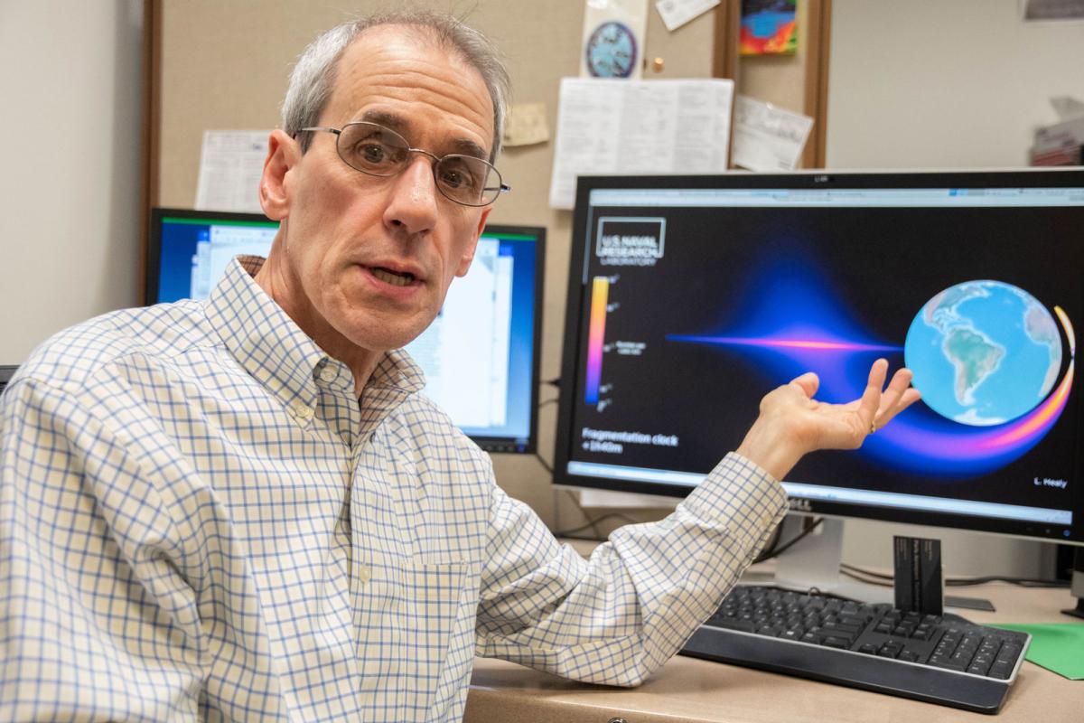 U.S. Naval Research Laboratory research physicist Liam Healy explains a model for a velocity distribution of fragmenting satellite debris. NRL Photo by Emanuel Cavallaro.