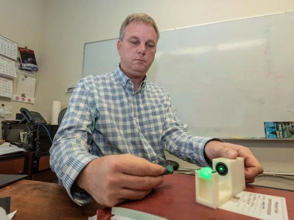 Andrew Nicholas, section head of the U.S. Naval Research Laboratory's Sensor Development and Applications, demonstrates the laser function of the Project LARADO demo. NRL Photo by Emanuel Cavallaro.