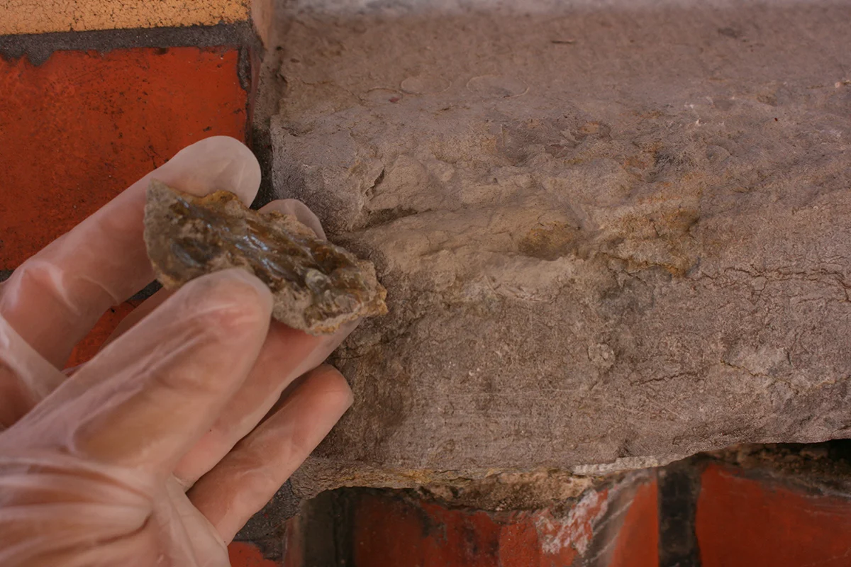  Del av kalkstenen som lossnat limmas på plats. 