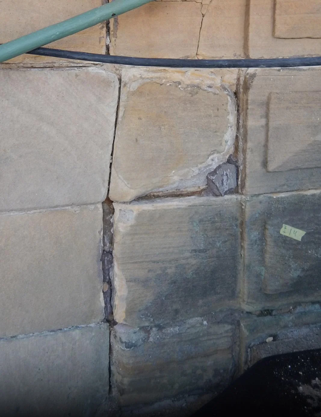  Skadad sten, saknad fog samt biologisk påväxt. 