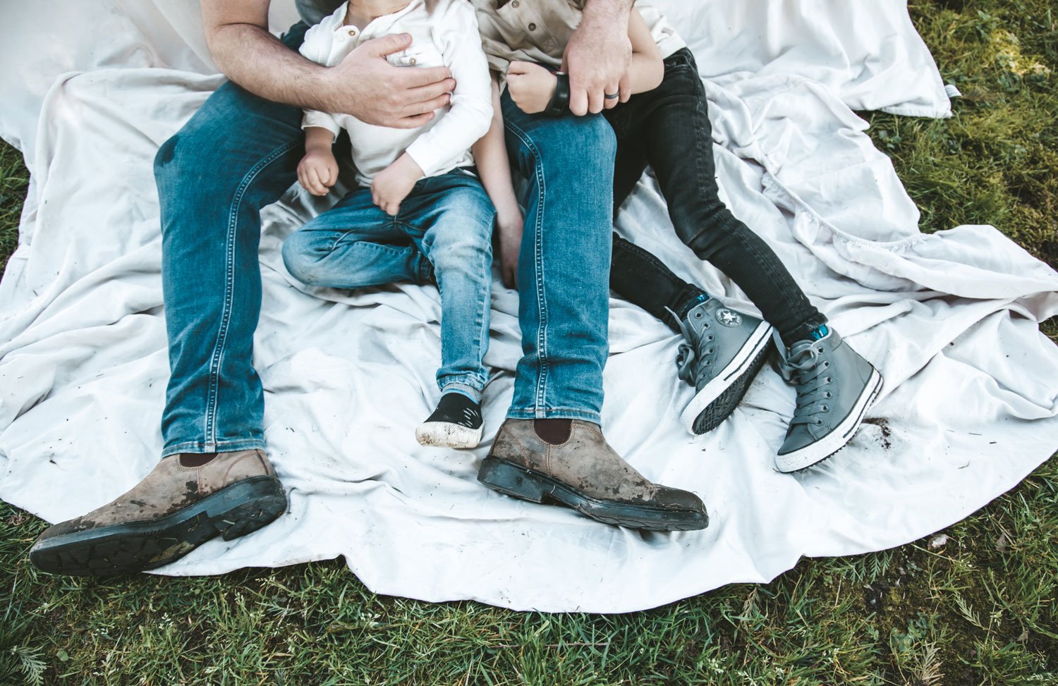 man-sitting-with-his-sons-in-the-grass.jpg