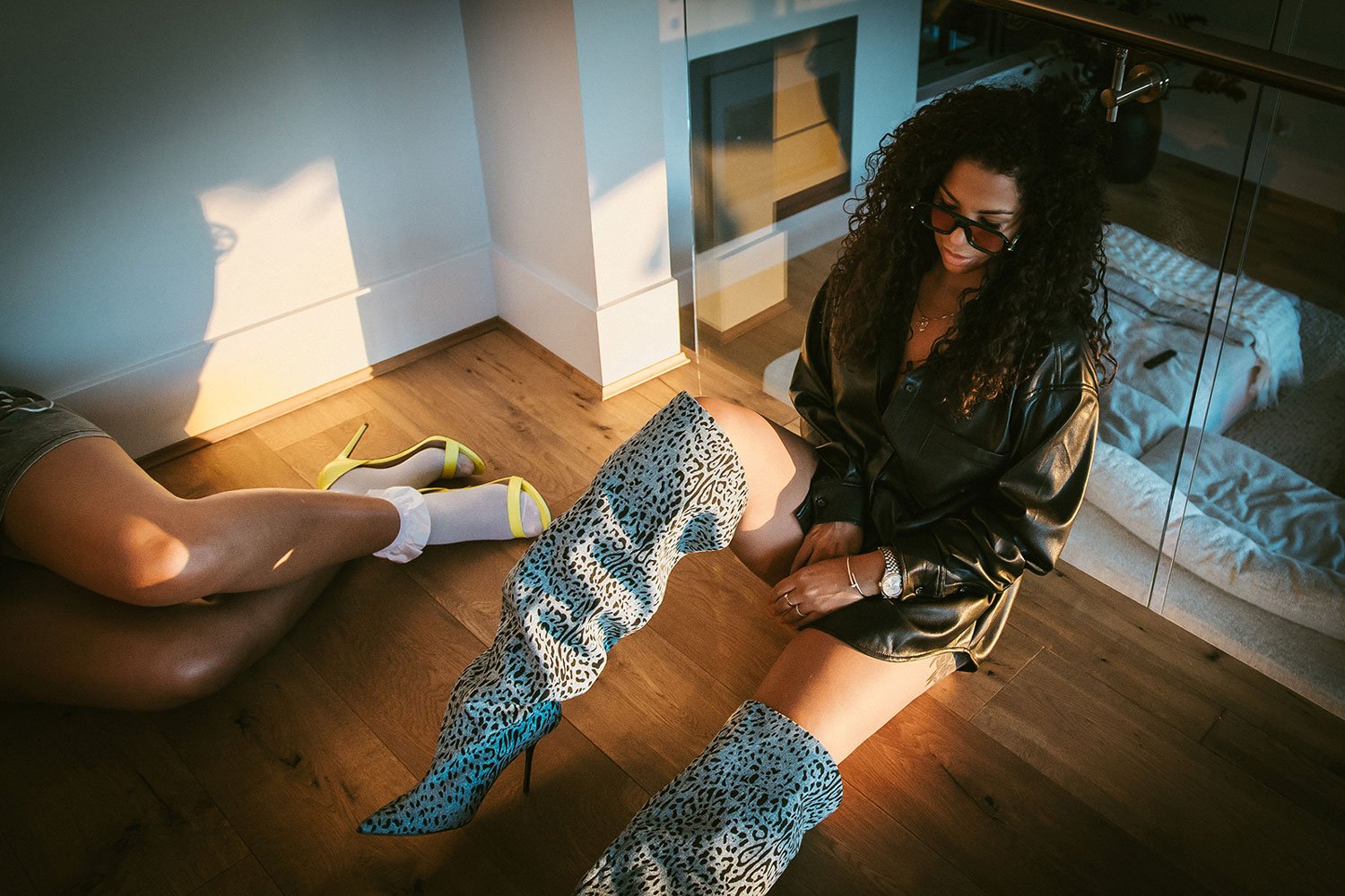 woman-in-tall-boots-sitting-against-glass-railing.jpg