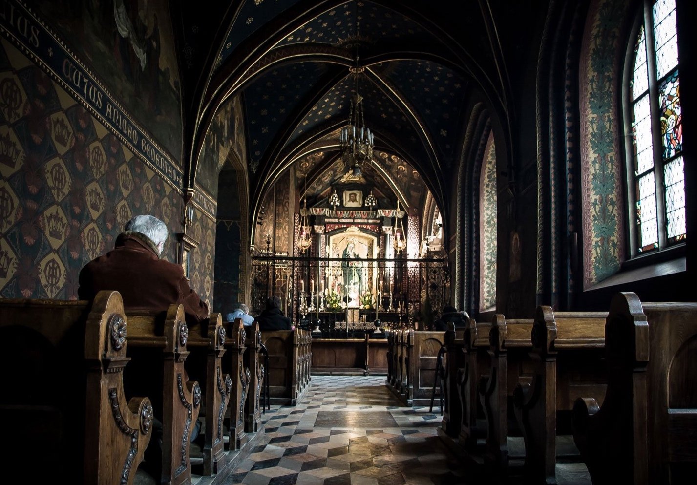 man-sitting-in-church-pew-moody-travel-photography-krakow.jpg