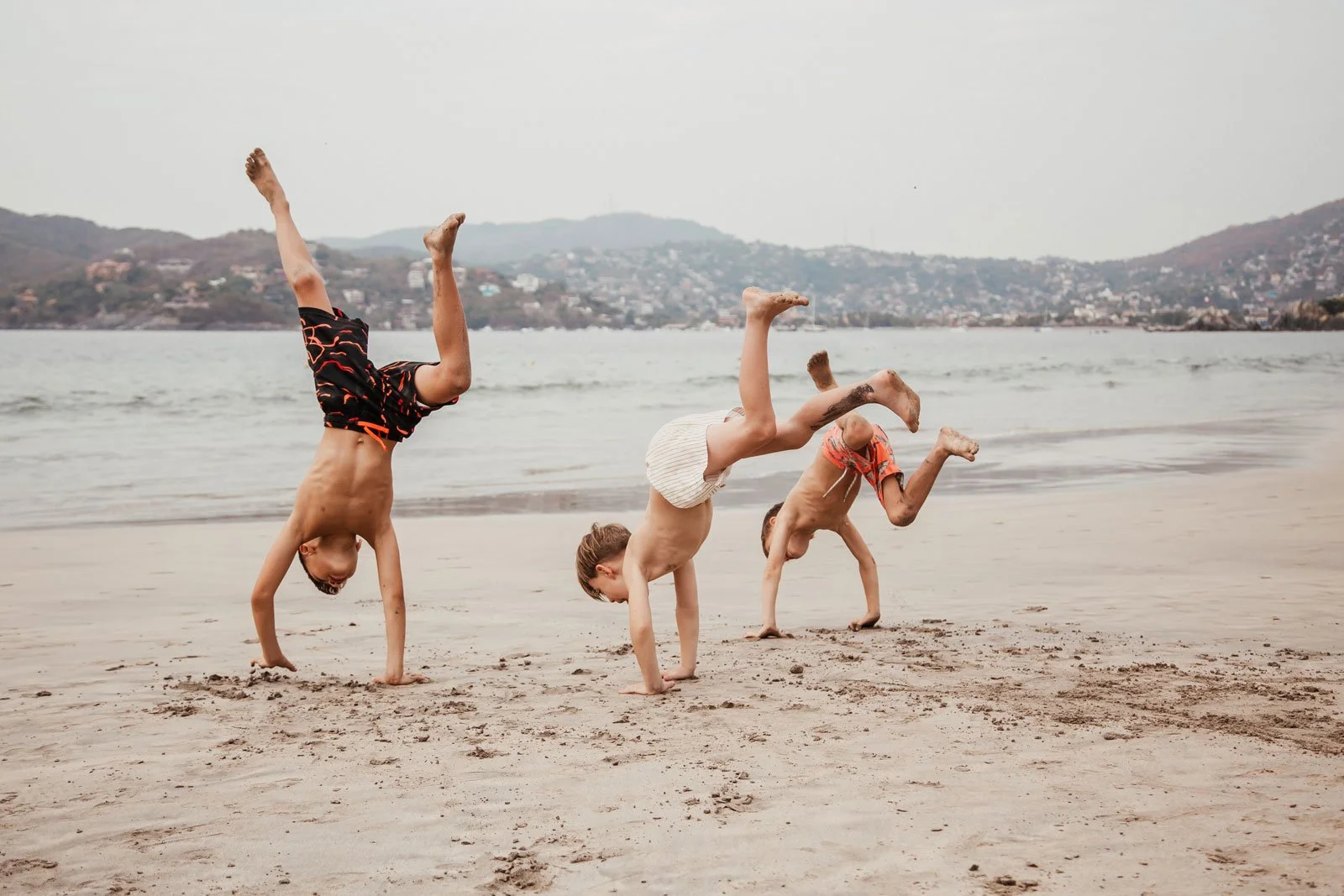 travel-family-photography-kids-doing-cartwheels-on-beach.jpg