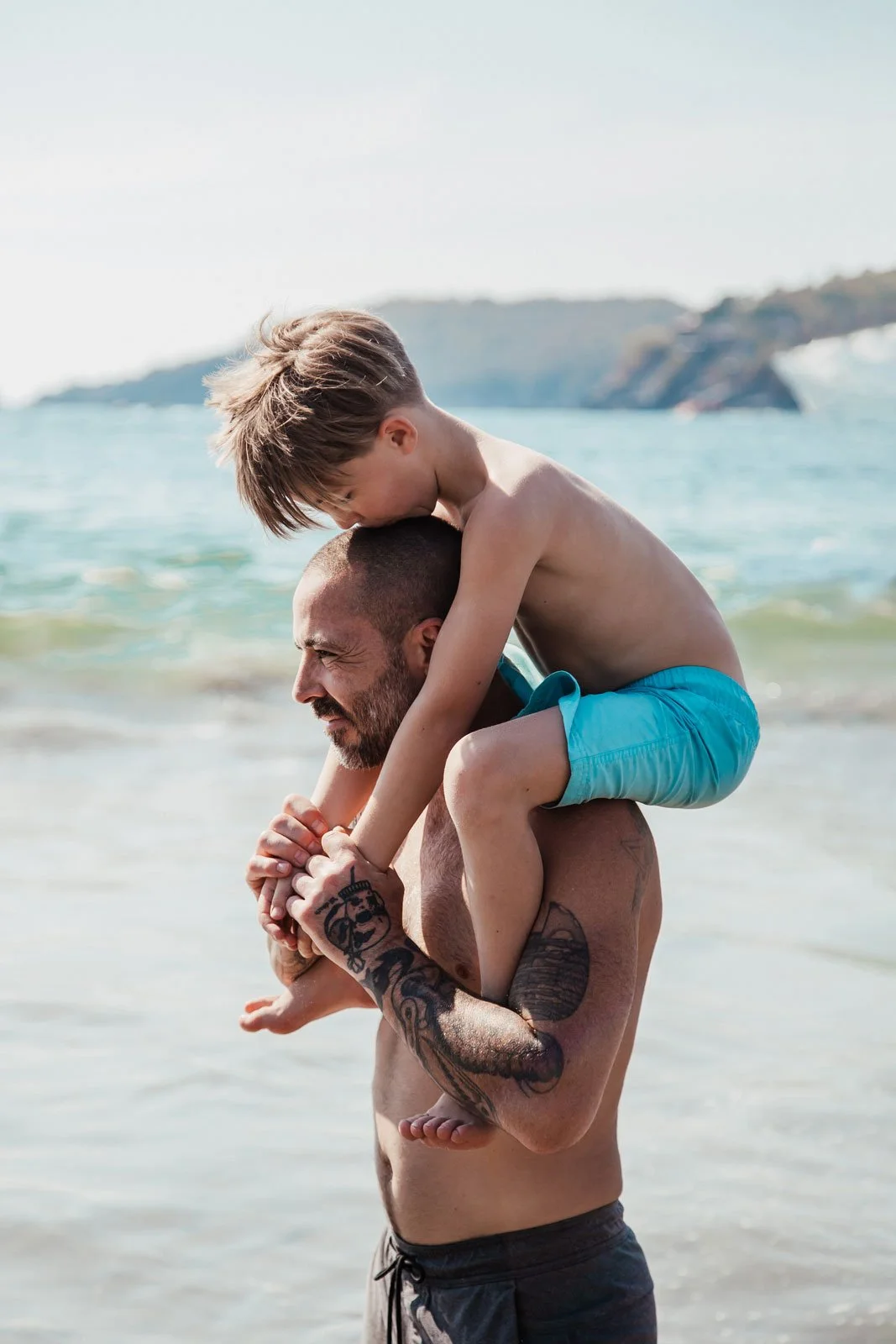 travel-lifestyle-family-photography-dad-and-son-hugging-at-beach.jpg