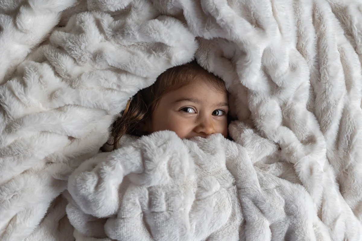 tri-cities-bc-family-photographer-in-home-toddler-peeking-in-blanket.jpg