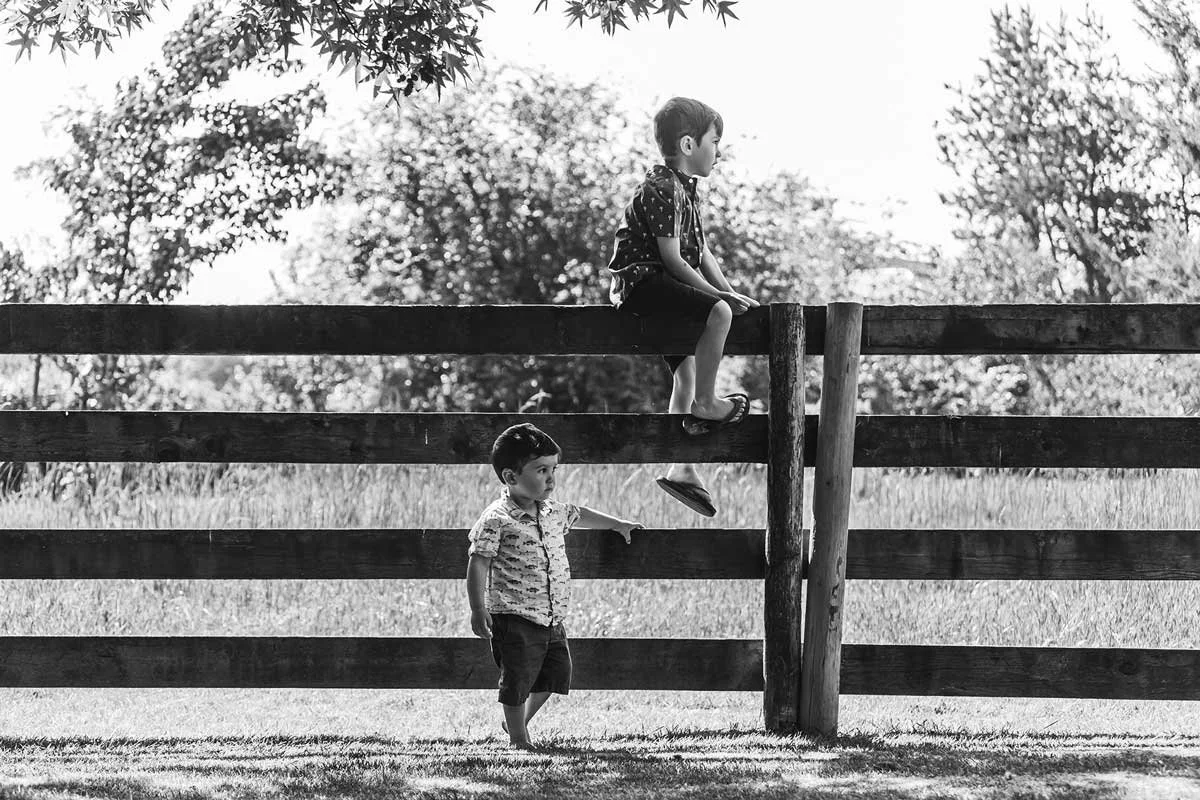 tri-cities-bc-family-photography-black-and-white-kids-on-fence.jpg