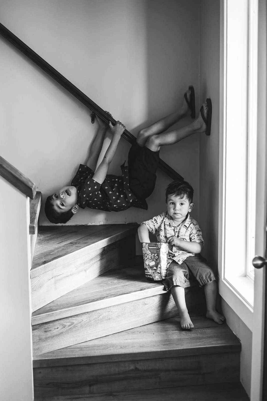 tri-cities-bc-family-photography-black-and-white-kids-on-stairs-candid.jpg