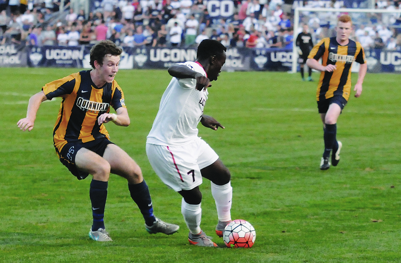 Junior Kwame Awuah (right) dribbles away from a Quinnipiac player at Joseph J. Morrone Stadium on Aug. 31, 2015. (Amar Batra/The Daily Campus)