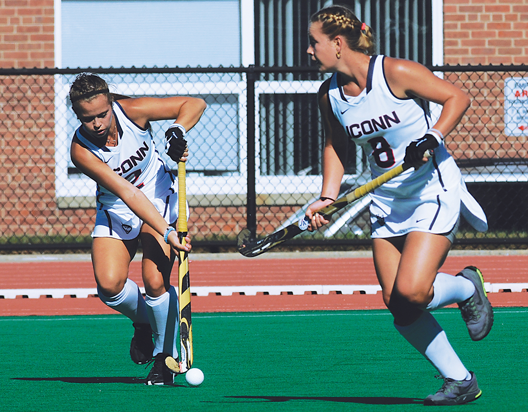 UConn junior forward Monica Fleming (left) passes the ball past sophomore forward Casey Umstead during a UConn field hockey game at the Sherman Family Sports Complex in Storrs, Connecticut. (Bailey Wright/The Daily Campus)