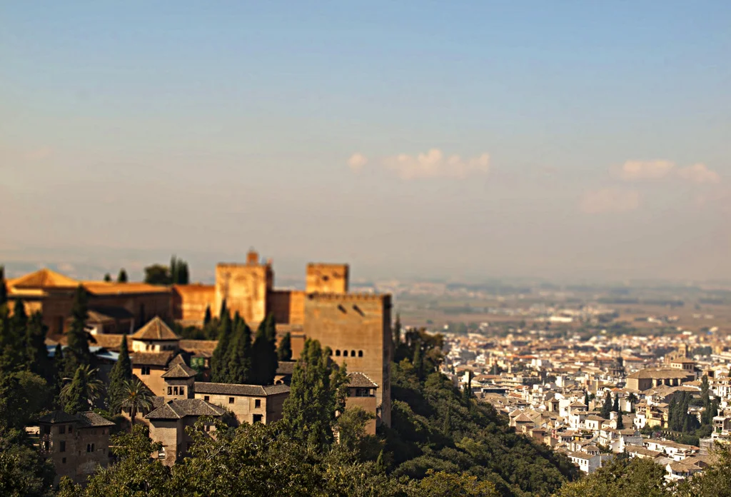 A view of Granada, Spain that shows the Alhambra, an Islamic fortress that was built in the 11th century and is currently Spain's number one tourist attraction, rising high in the hills on the left. (Kevin Poh/Flickr). 