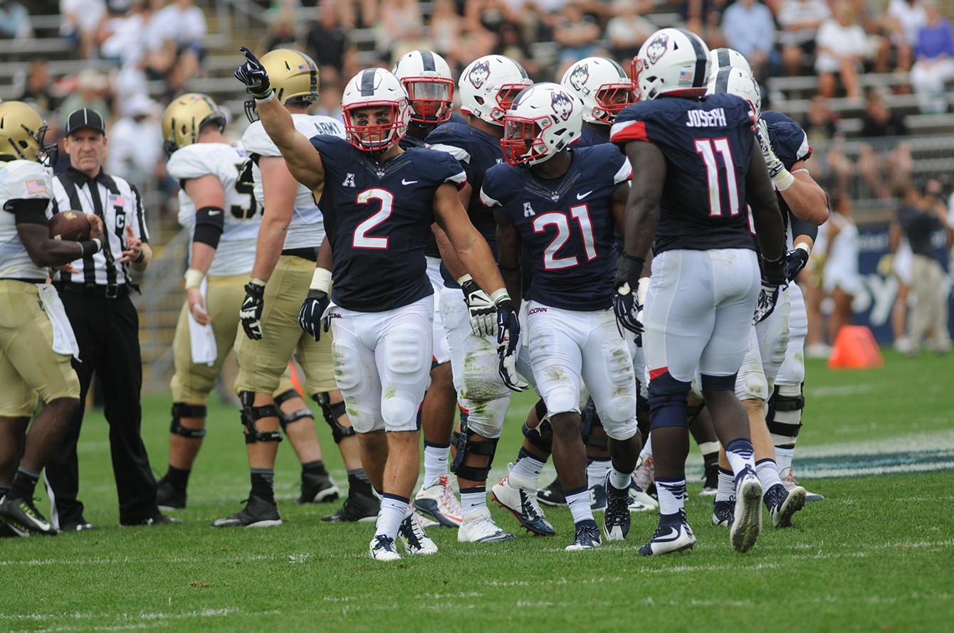 UConn football linebacker Graham Stewart (2) and other members of the Huskies' defense huddle between plays during UConn's game against Army at Pratt & Whitney Stadium at Rentschler Field in East Hartford, Connecticut on Saturday, Sept. 12, 2015. (Bailey Wright/The Daily Campus)