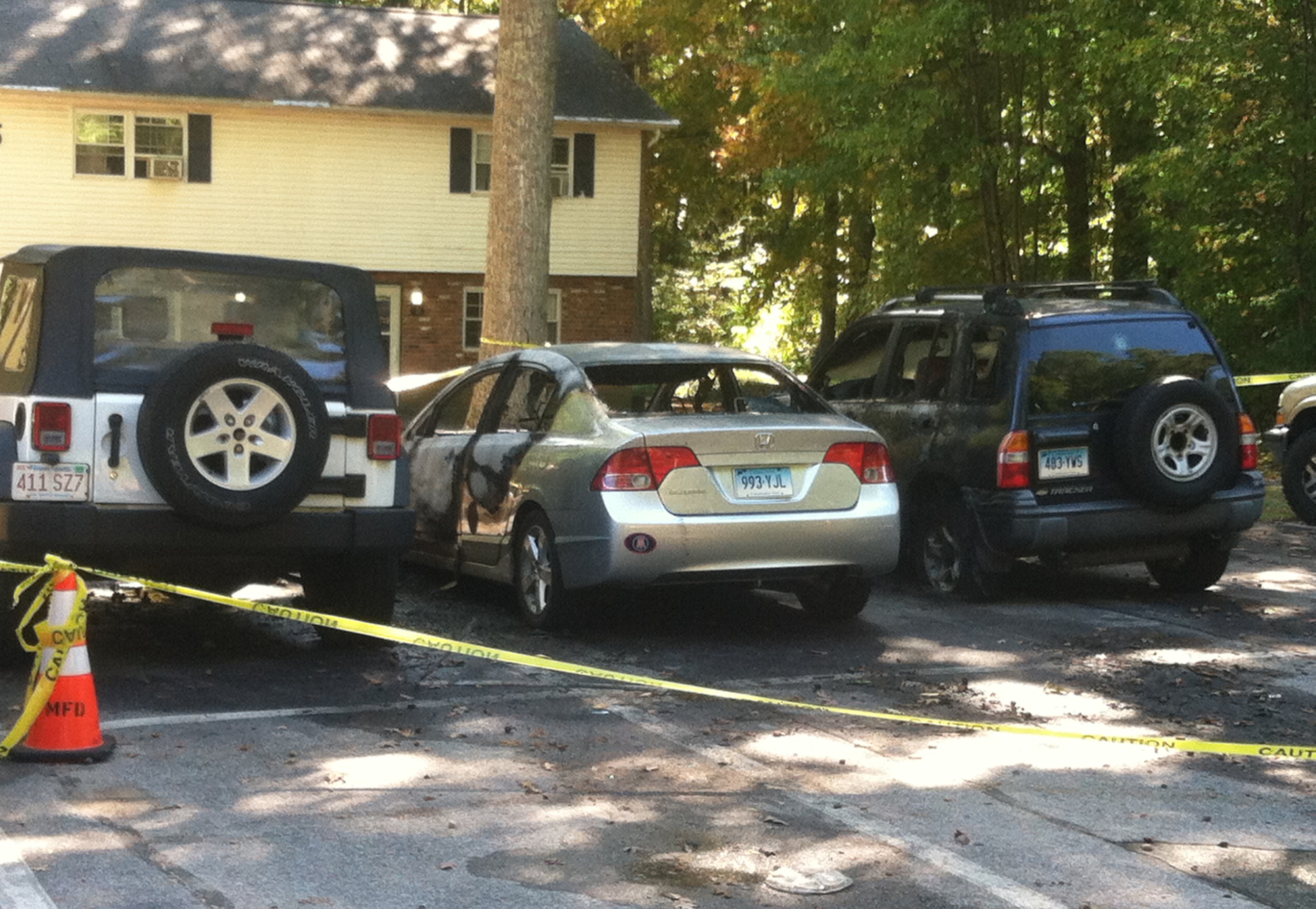 In this photo, three cars that were on fire in front of a Carriage House apartment are pictured. The silver Honda (middle) was originally set on fire, and the fire spread to the cars on the left and right. (Courtesy)