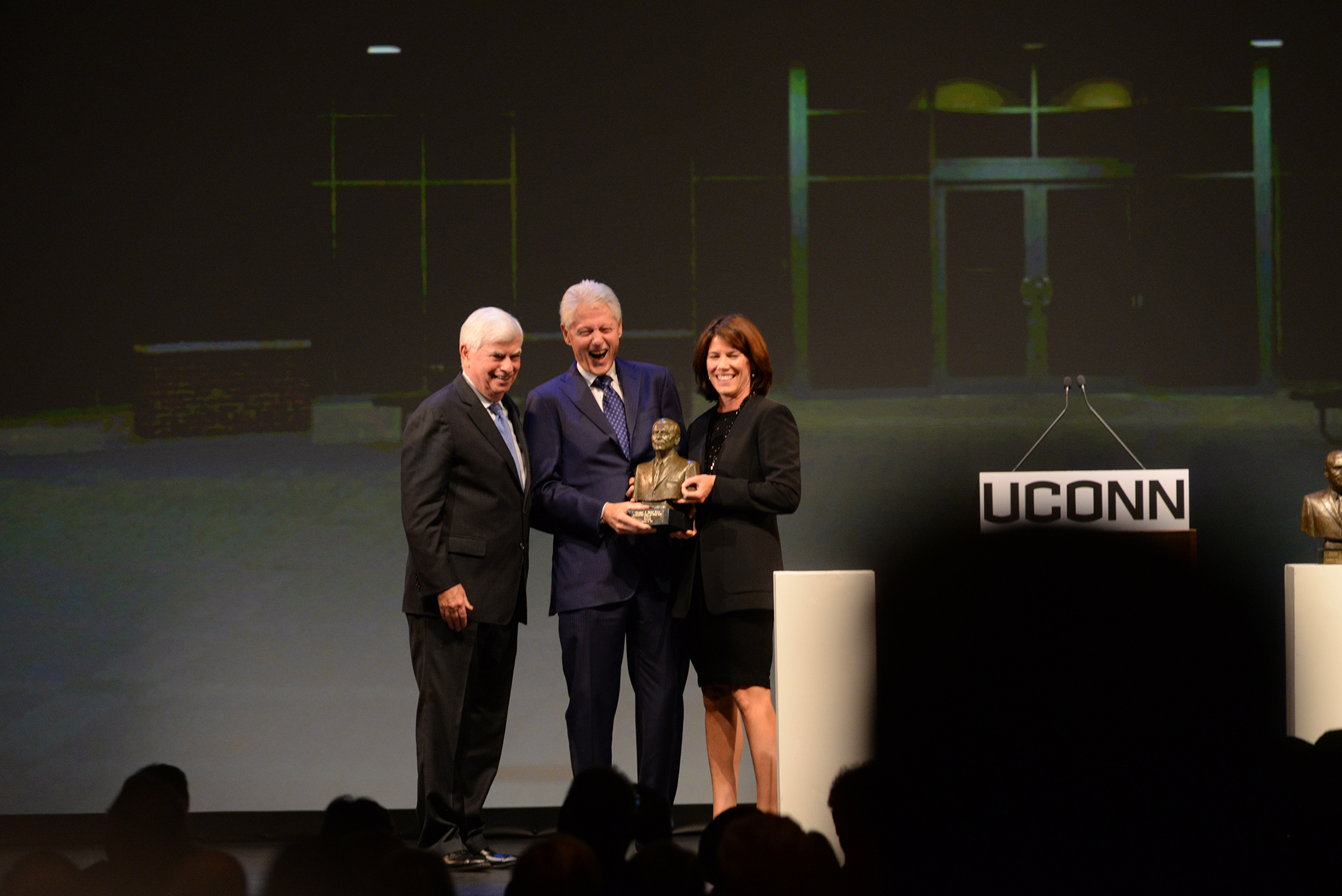 Former President Bill Clinton, center, accepts the Thomas J. Dodd Prize in International Justice and Human Rights from Helena Foulkes (right), acting chair, national advisory board of the Thomas J. Dodd Research Center and former Connecticut Sen. Chris Dodd (left) at the Jorgensen Center for the Performing Arts in Storrs, Connecticut on Thursday, Oct. 15, 2015. (Ashley Maher/The Daily Campus)