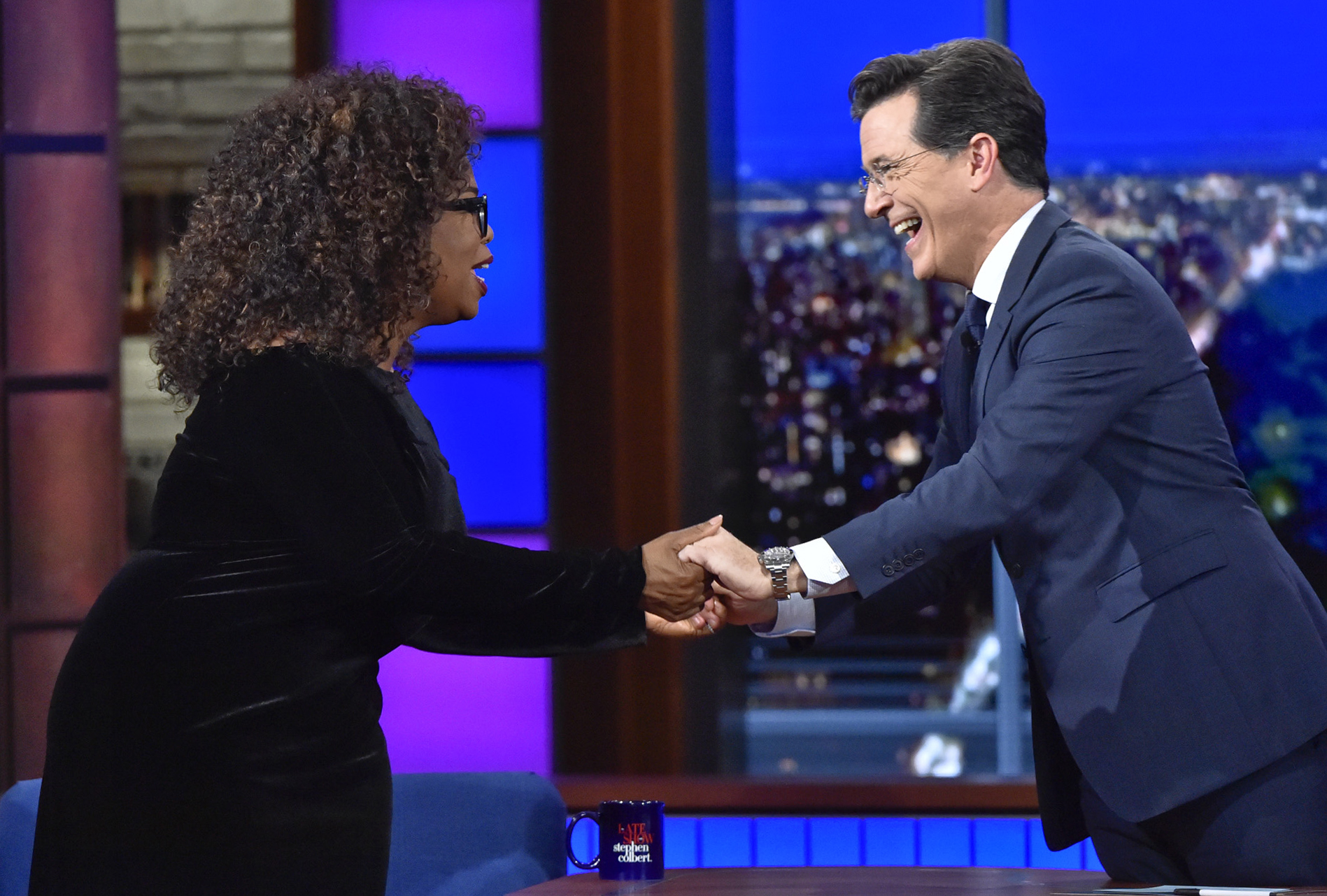 In this photo provided by CBS, host Stephen Colbert, right, welcomes Oprah Winfrey, the chairman and chief executive officer of OWN, to the “Late Show with Stephen Colbert” in New York, Thursday, Oct. 15, 2015. (John Paul Filo/CBS via AP)