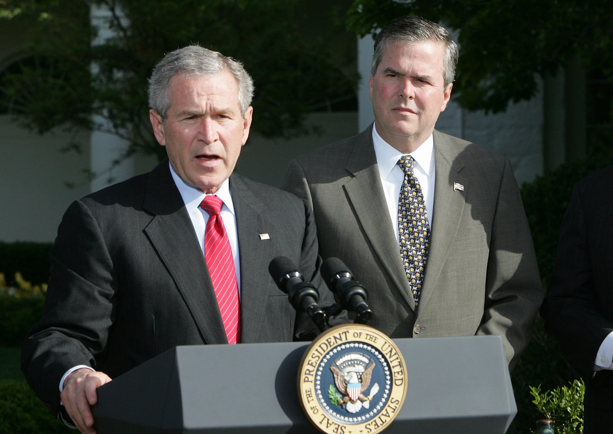 In this April 19, 2006 file photo, President George W. Bush, accompanied by his brother, then-Fla. Gov. Jeb Bush, speaks on the South Lawn at the White House in Washington. (Ron Edmonds, File/AP)
