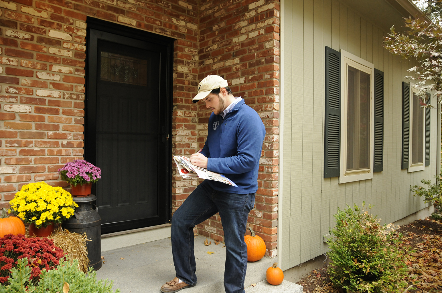 Sargent writes a personal note on a flyer to be left at a residences with no one home. Sargent and volunteers from the UConn College Republicans knocked on 60 doors in total during Saturday morning's door-to-door campaign efforts. (Amar Batra/The Daily Campus)
