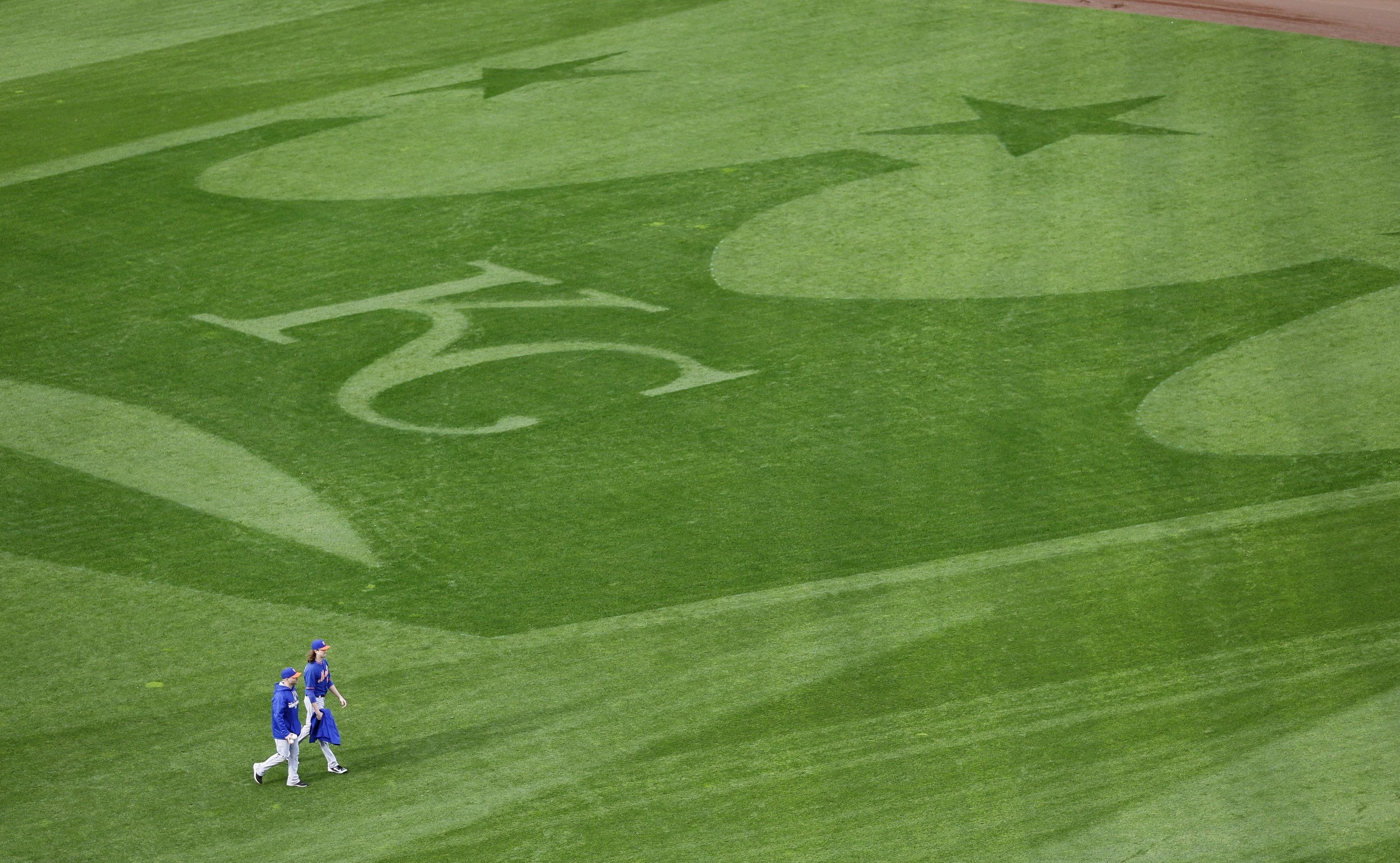 New York Mets starting pitcher Jacob deGrom, right, and bullpen catcher Dave Racaniello walk in the outfield during media day for the Major League Baseball World Series against the Kansas City Royals Monday, Oct. 26, 2015, in Kansas City, Mo. (David J. Phillip/AP)
