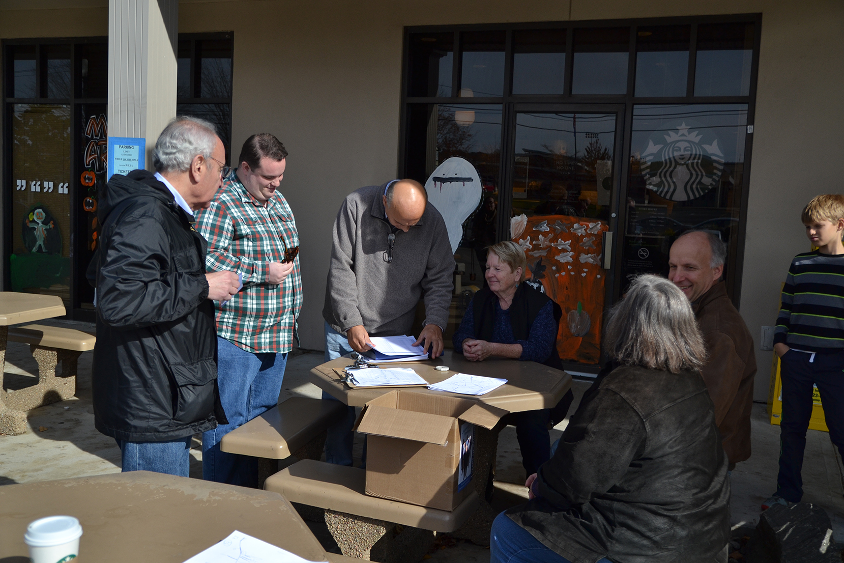 Town council member Paul Shapiro (left) and other members of Mansfield Democrats plan a campaign route in the Storrs Commons shopping area in Mansfield, Connecticut on Saturday, Oct. 31, 2015. Democrats campaigned door-to-door to raise awareness about their campaign. Election Day is Nov. 3. (Amar Batra/The Daily Campus)