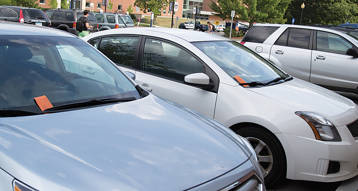 In this photo, cars are shown with orange UConn parking tickets on their windshields. Parking Services issued a statement via email last weekend warning students about an impending crackdown that will likely result in more tickets. (Amar Batra/The Daily Campus)