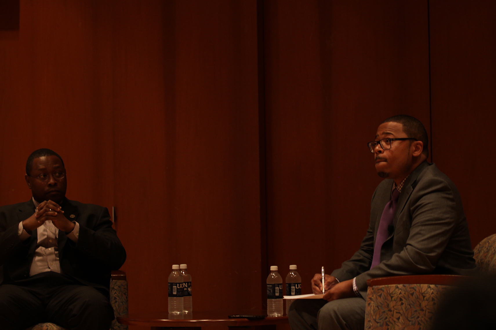 UConn assistant professor Dr. Erik Hines (right) and Ohio State University distinguished professor Dr. James L. Moore III sit in the Konover Auditorium during the forum "Black Males in Higher Education: A Conversation with Dr. James L. Moore III" on Thursday, Nov. 5, 2015. (Mei Buzzell/The Daily Campus)
