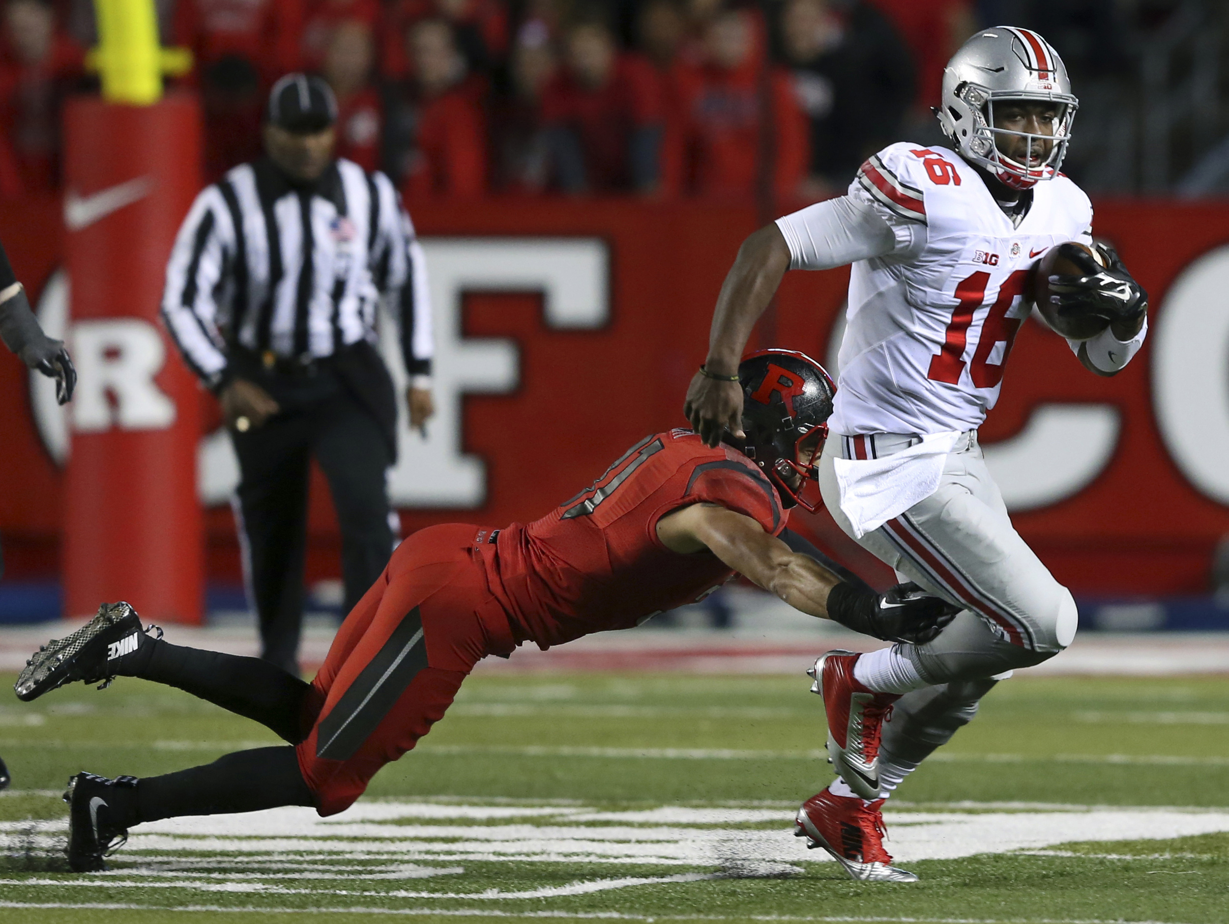 Ohio State quarterback J.T. Barrett (16) breaks a tackle by Rutgers defensive back Anthony Cioffi (31) during the first half of an NCAA college football game Saturday, Oct. 24, 2015, in Piscataway, N.J. (AP).
