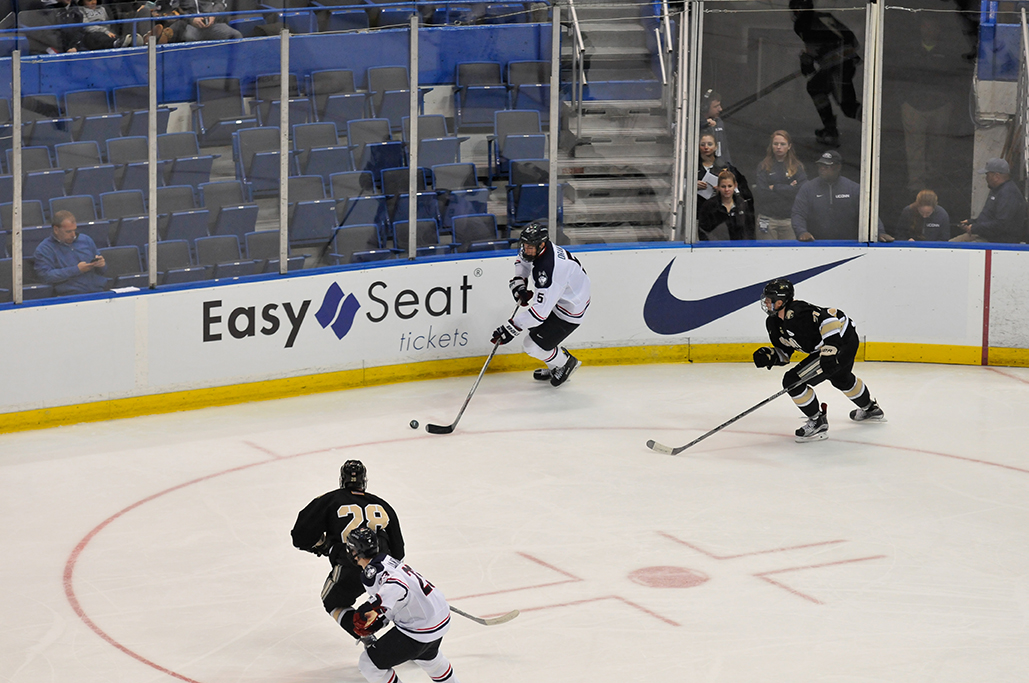 UConn sophomore defender David Drake (middle) handles the puck during the Huskies' game against Army at the XL Center in Hartford, Connecticut on Tuesday, Nov. 10, 2015. The team is currently riding a six-game losing streak. (Amar Batra/The Daily Campus)