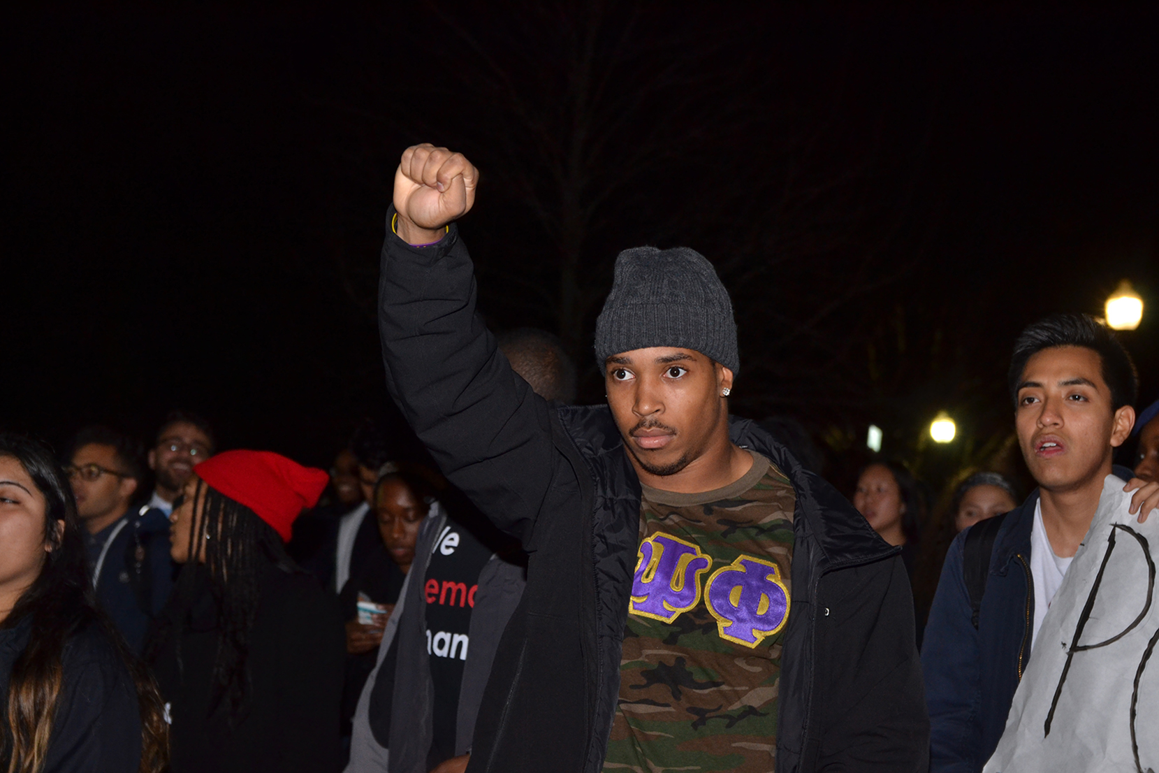 UConn student Josh Marriner, also a running back on the UConn football team, holds up a fist while walking in the "March for Justice, Empowerment and Solidarity" on Fairfield Way in Storrs, Connecticut on Thursday, Nov. 19, 2015. (Amar Batra/The Daily Campus)