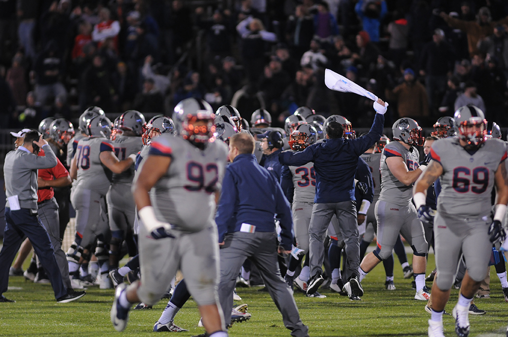 Members of the UConn football team celebrate after upsetting No. 13 Houston at Pratt & Whitney Stadium at Rentschler Field in East Hartford, Connecticut on Saturday, Nov. 21, 2015. The win made the Huskies bowl eligible for the first time since 2010. (Amar Batra/The Daily Campus)