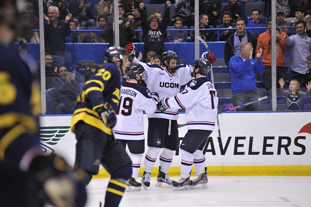 UConn men's ice hockey forward Jeff Wight (middle) celebrates with teammates Evan Richardson (left) and Jesse Schwartz (right) after scoring a goal during the Huskies' game against Merrimack at XL Center in Hartford, Connecticut on Friday, Dec. 11, 2015. (Jason Jiang/The Daily Campus)