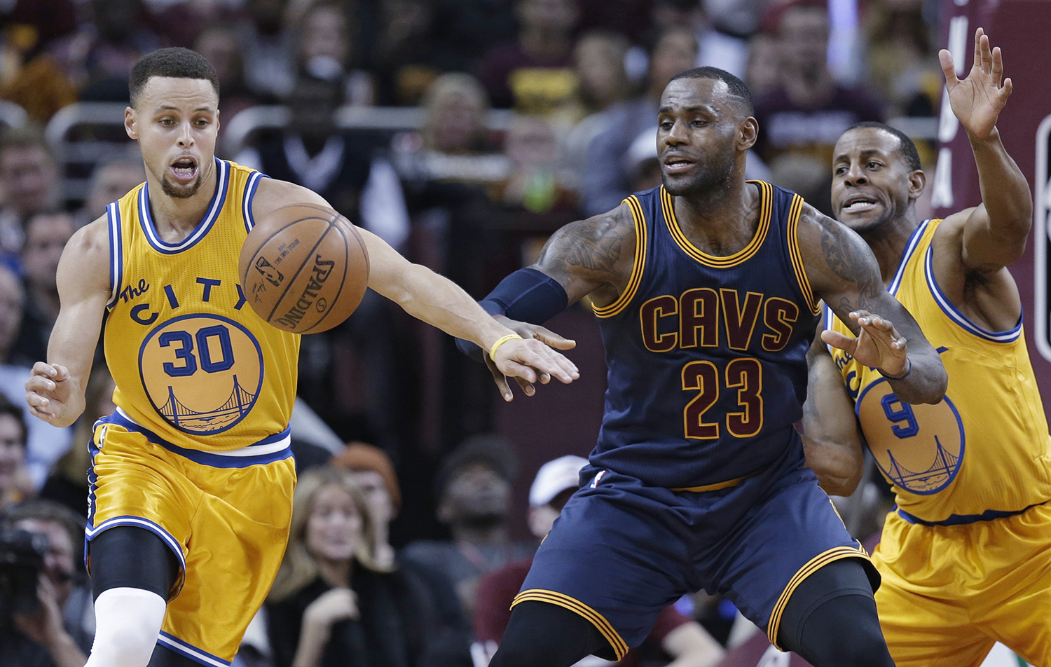 Golden State Warriors ’ Stephen Curry (30) knocks the ball loose from Cleveland Cavaliers ' LeBron James (23) in the first half of an NBA basketball game, Monday, Jan. 18, 2016, in Cleveland. Andre Iguodala (9) is at right. (AP Photo/Tony Dejak)