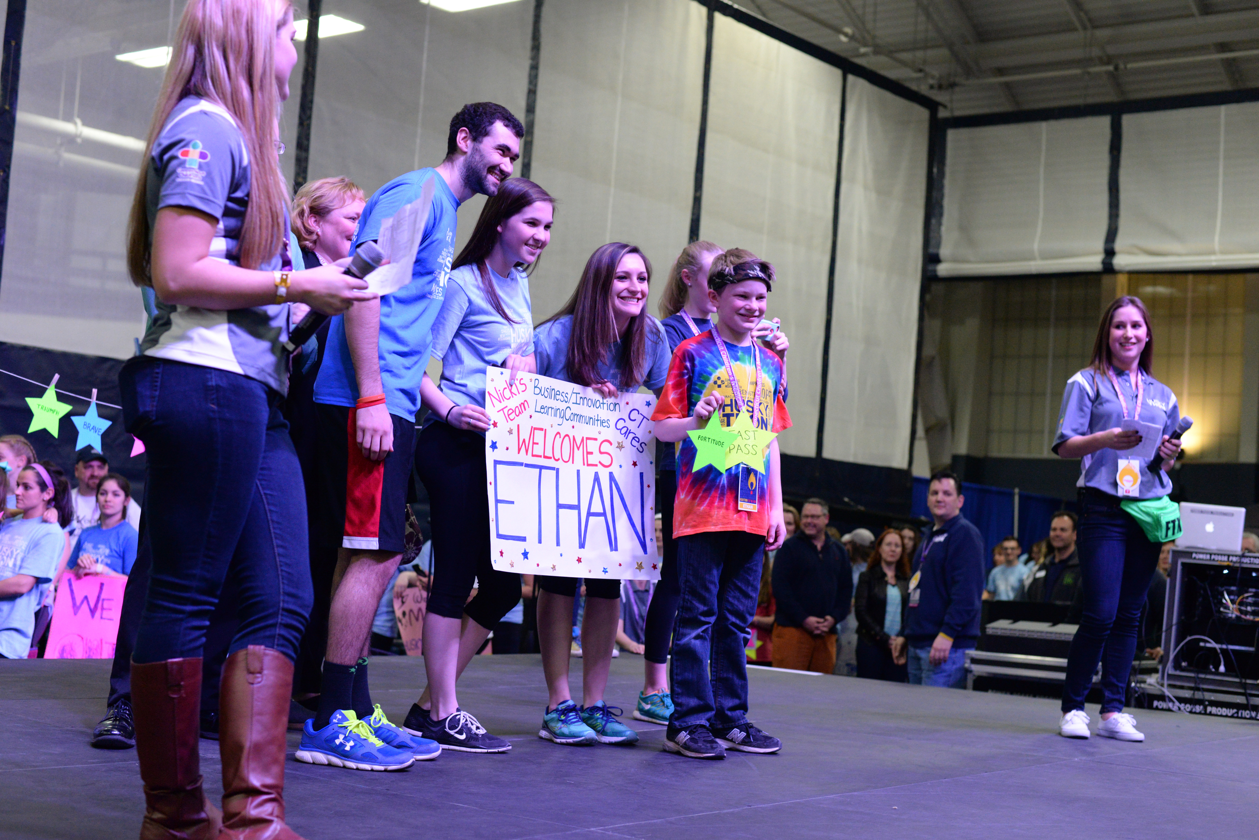 The team of Igor Lekontsev, the HuskyTHON dancer who received the $1,989 donation, stands on stage with their HuskyTHON child at the beginning of the dance marathon for Connecticut Children's Medical Center. (Amar Batra/The Daily Campus)