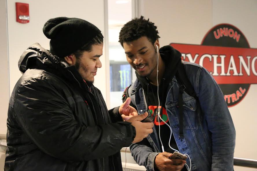 Sathia Diaz (left) shares what music he's listening to on his iPhone in the UConn Student Union on Thursday, Feb. 25, 2016. (Diler Haji/The Daily Campus)