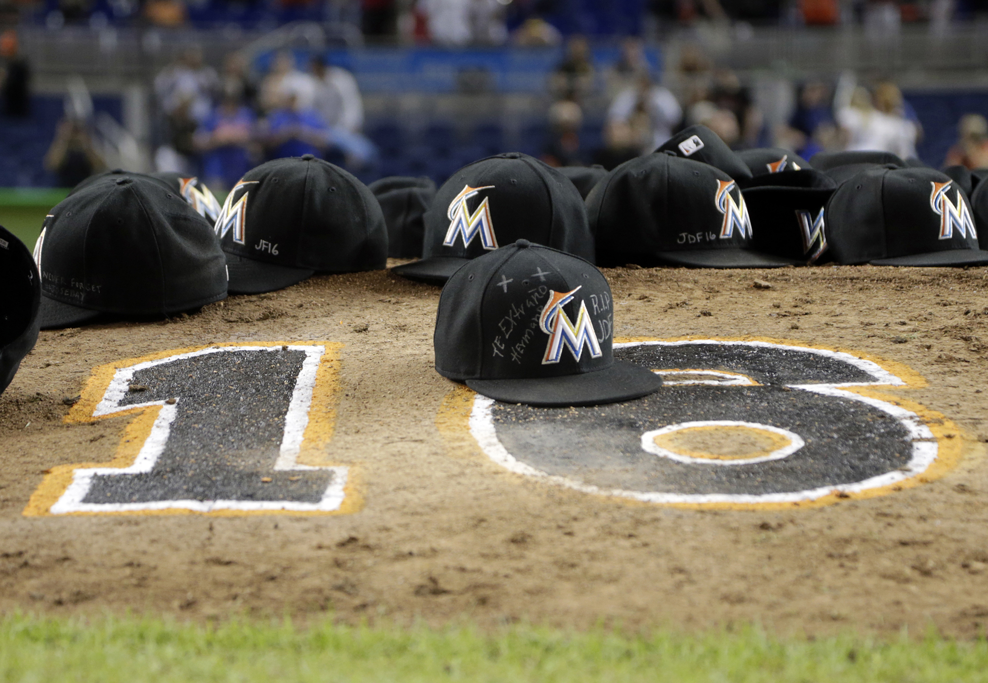 Miami Marlins ball caps left by the players sit on the pitching mound with the number 16 in honor of pitcher Jose Fernandez after a baseball game against the New York Mets, Monday, Sept. 26, 2016, in Miami. The Marlins defeated the Mets 7-3. (AP Photo/Lynne Sladky)