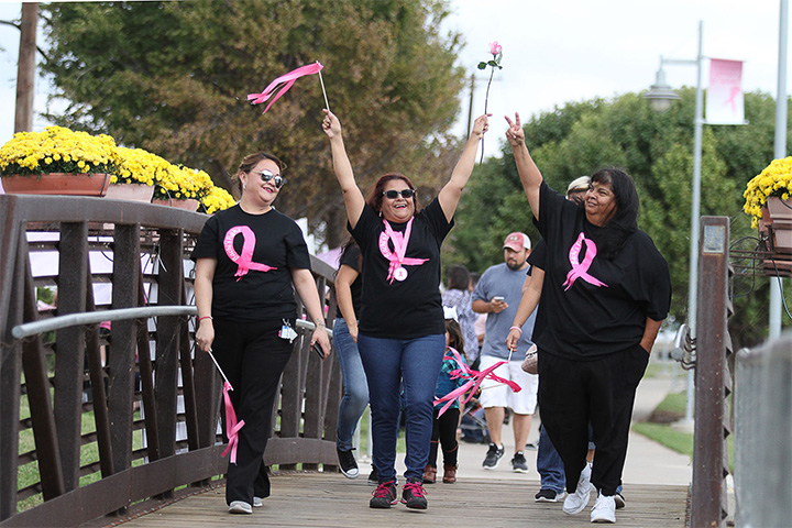 Breast cancer survivor Beatriz Madero, center, makes her victory lap around the pond with family at Pink the Park Breast Cancer Awareness event at Memorial Gardens Park Sunday, Oct.9, 2016, in Odessa, Texas. (Jacob Ford/Odessa American via AP)